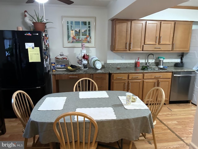 kitchen featuring sink, black fridge, stainless steel dishwasher, ornamental molding, and light hardwood / wood-style floors