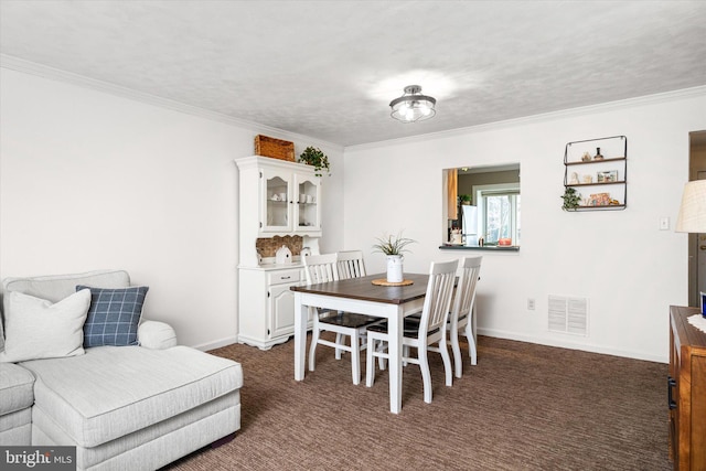 dining area with ornamental molding and dark carpet