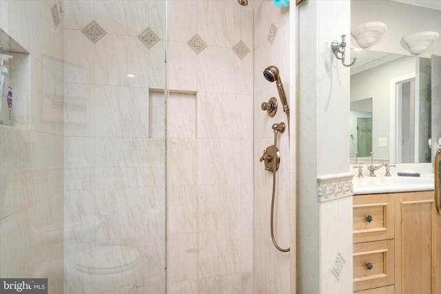 bathroom with vanity, crown molding, and tiled shower