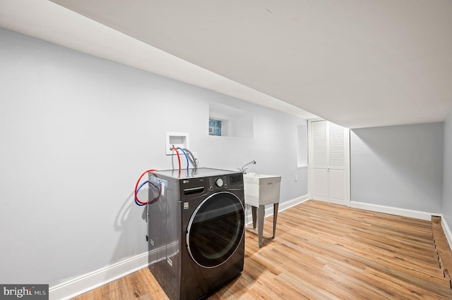 laundry room with washer / dryer and light hardwood / wood-style flooring