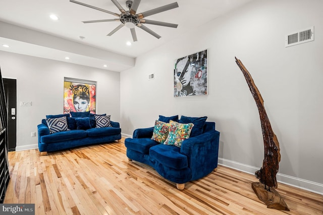 living room featuring wood-type flooring and ceiling fan