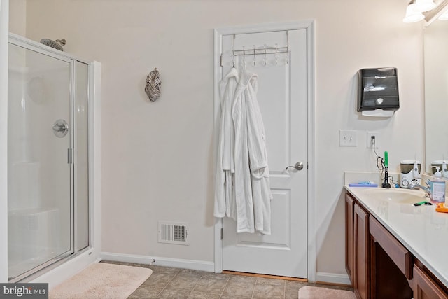 bathroom featuring visible vents, baseboards, vanity, and a shower stall