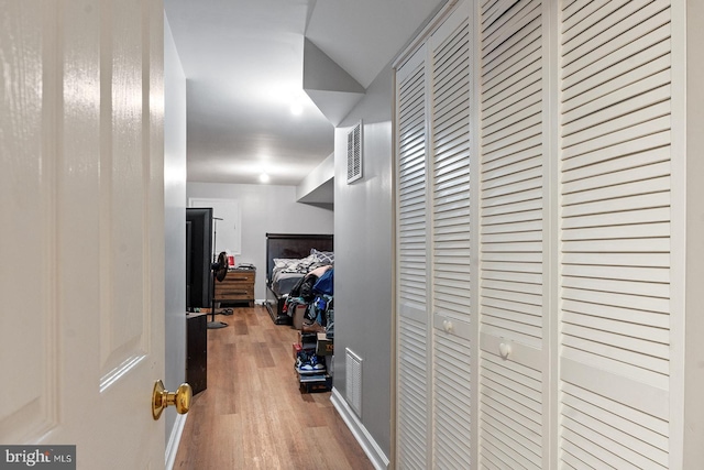 corridor featuring visible vents and wood finished floors