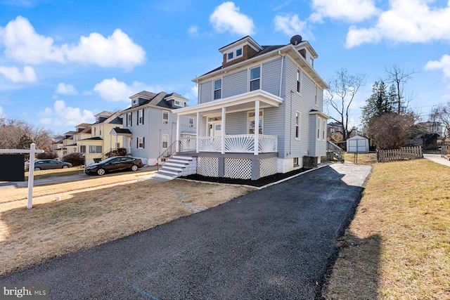 view of front of property featuring central AC, a front yard, and a porch