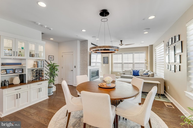 dining room with a fireplace and dark wood-type flooring