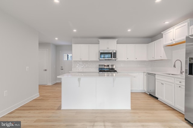 kitchen with appliances with stainless steel finishes, a center island, and white cabinets