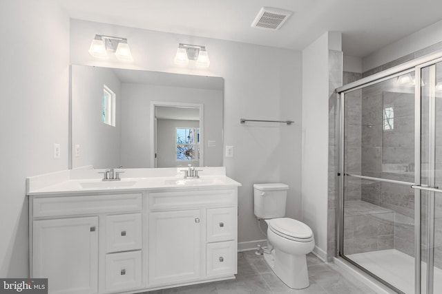 bathroom featuring vanity, a shower with door, and toilet