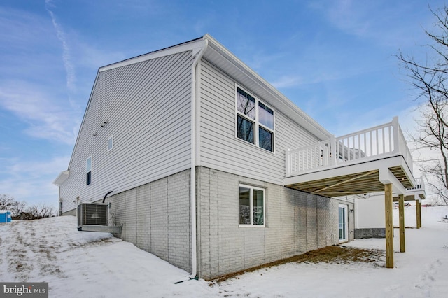 snow covered back of property with central AC unit