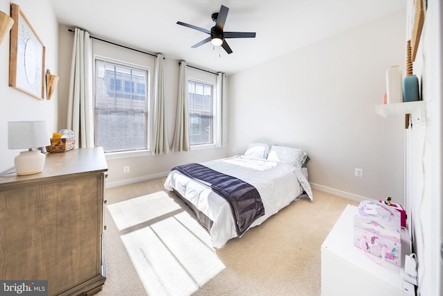 bedroom with light carpet, ceiling fan, and baseboards