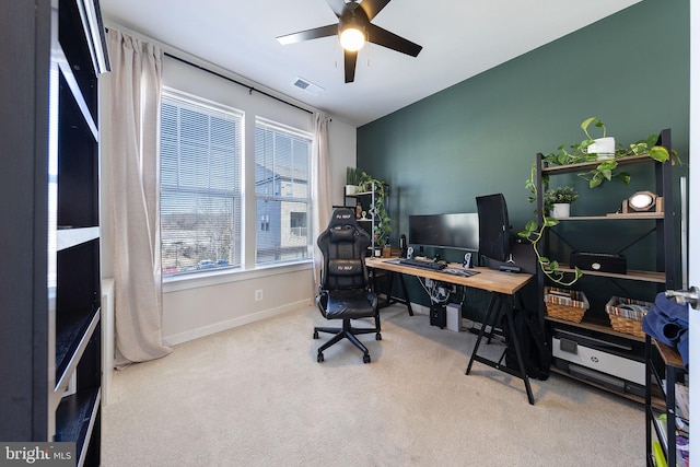 carpeted office space featuring visible vents, ceiling fan, and baseboards