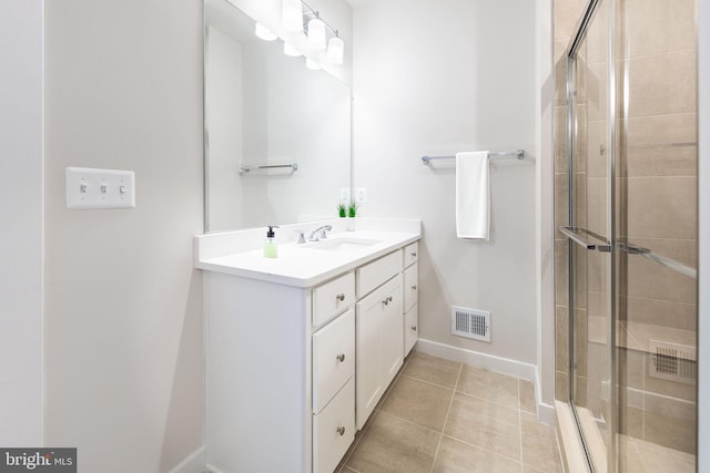 full bath with visible vents, a shower stall, vanity, tile patterned flooring, and baseboards