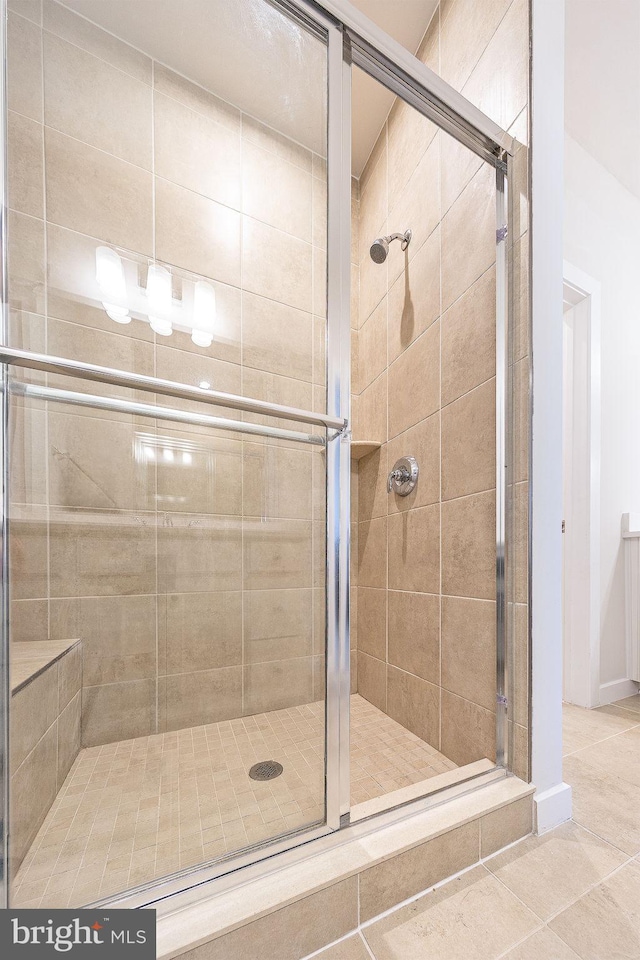 bathroom featuring tile patterned flooring and a shower stall