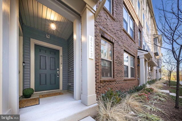 entrance to property featuring brick siding