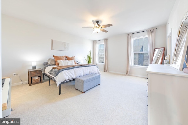 bedroom featuring light carpet, ceiling fan, and baseboards