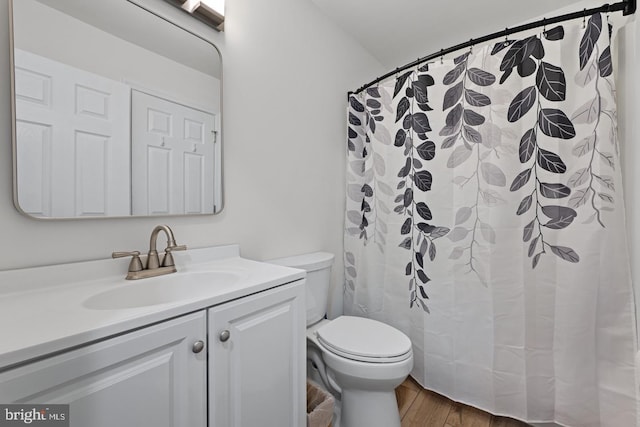 bathroom with a shower with curtain, vanity, hardwood / wood-style floors, and toilet