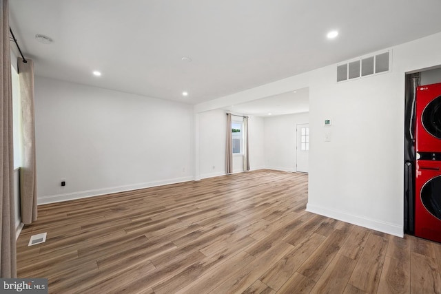 entryway with stacked washer and clothes dryer and wood-type flooring