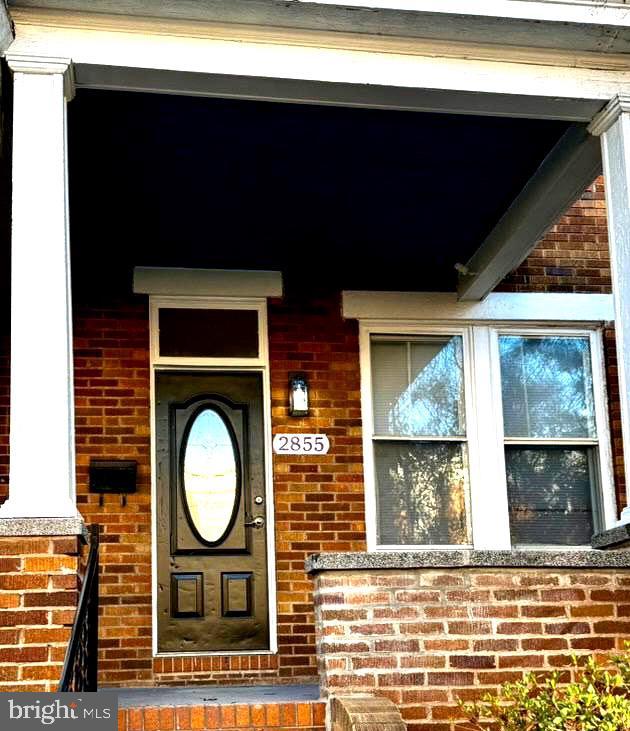 doorway to property with brick siding