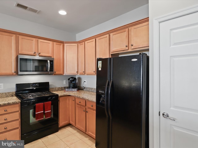 kitchen with light tile patterned flooring, light stone countertops, and black appliances