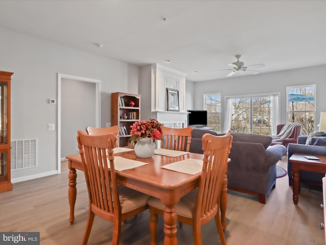 dining space with ceiling fan and light hardwood / wood-style floors