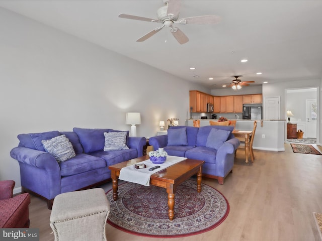 living room featuring ceiling fan and light wood-type flooring