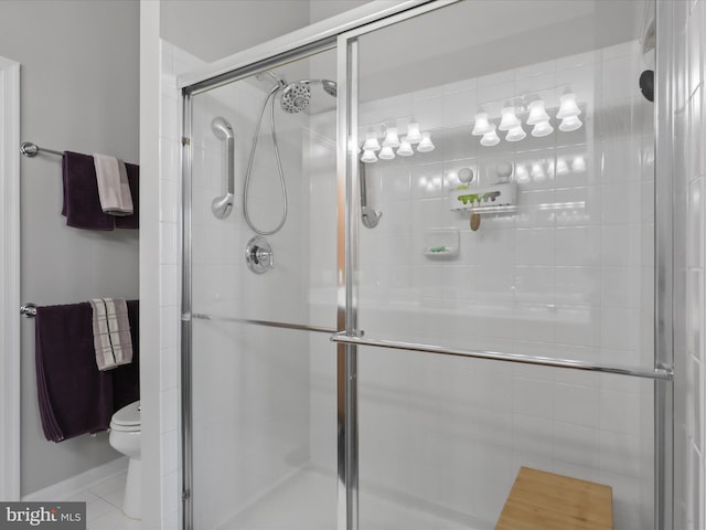 bathroom with tile patterned flooring, a shower with shower door, and toilet