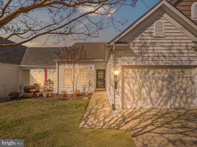 view of front of property featuring a garage and a lawn