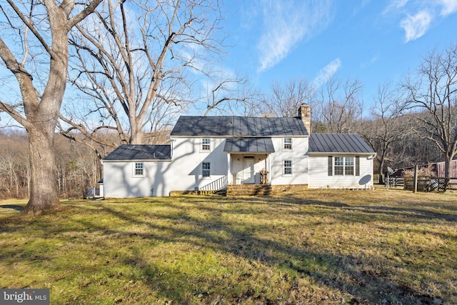 rear view of property with a lawn