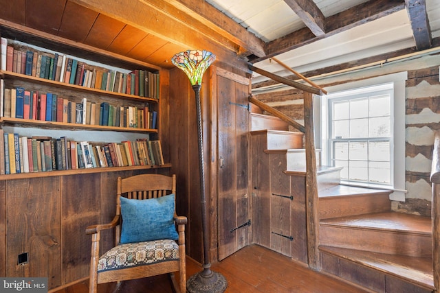 unfurnished room with beam ceiling, hardwood / wood-style flooring, wooden walls, and wooden ceiling