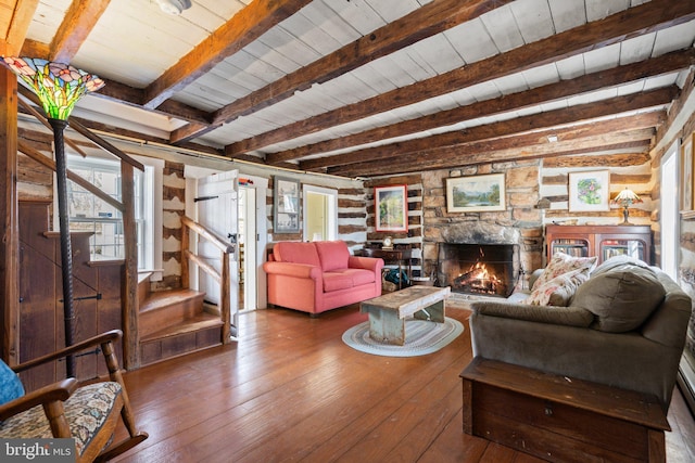 living room with a stone fireplace, dark hardwood / wood-style floors, wooden ceiling, and beam ceiling