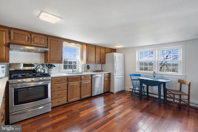 kitchen featuring a baseboard radiator, stainless steel appliances, dark hardwood / wood-style flooring, and sink