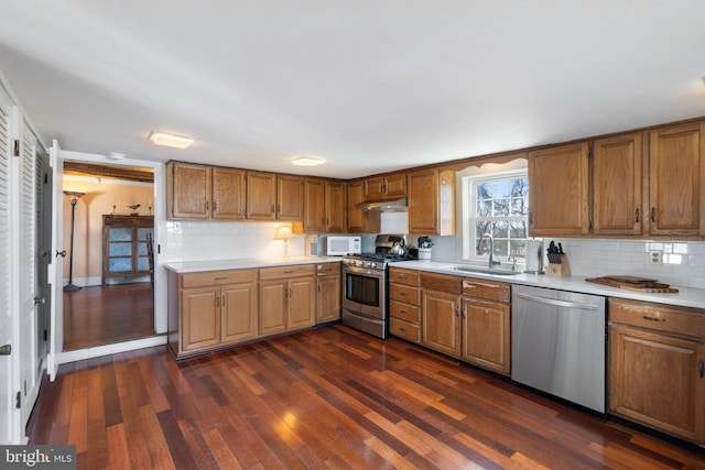 kitchen with stainless steel appliances, dark hardwood / wood-style flooring, sink, and decorative backsplash