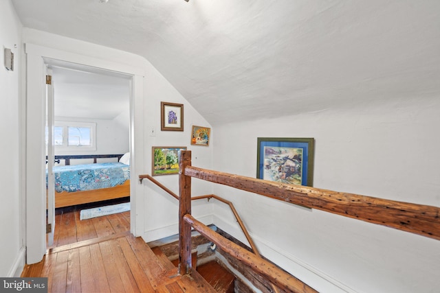 hallway featuring lofted ceiling and light wood-type flooring