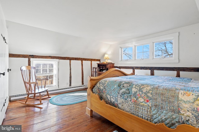 bedroom featuring vaulted ceiling, wood-type flooring, and baseboard heating