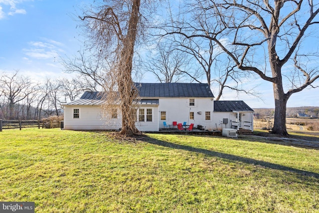 back of house featuring central AC and a lawn