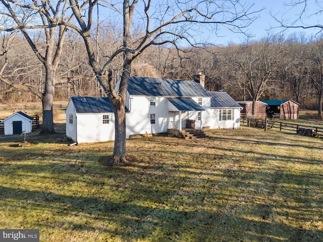 view of side of home with a lawn and a storage shed