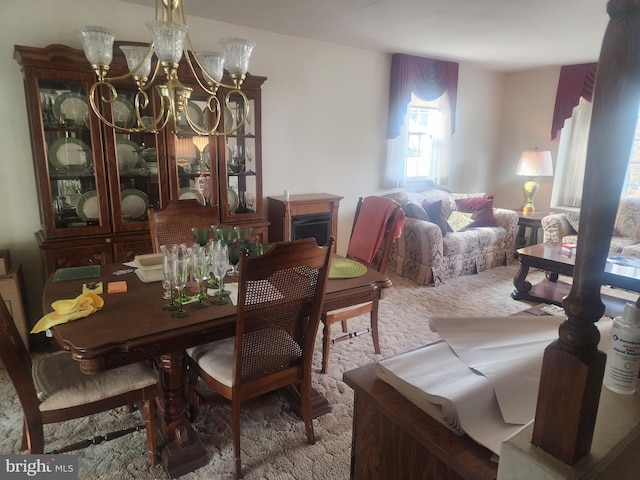 dining area featuring carpet flooring and an inviting chandelier