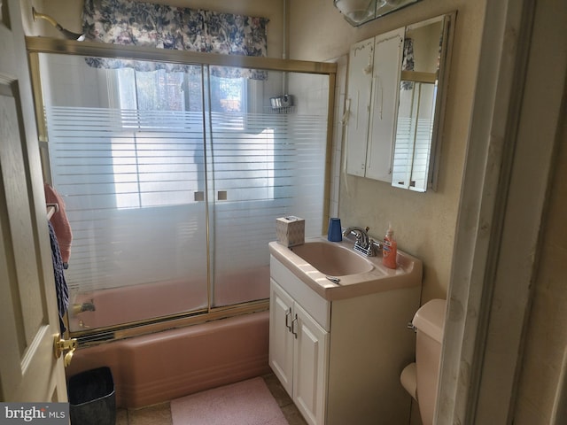 full bathroom with toilet, vanity, and bath / shower combo with glass door