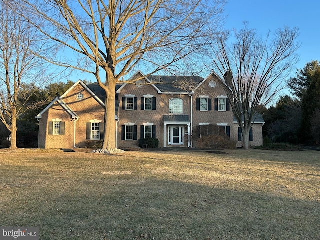 view of front of home featuring a front lawn and brick siding