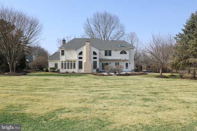 back of house with a lawn and a chimney