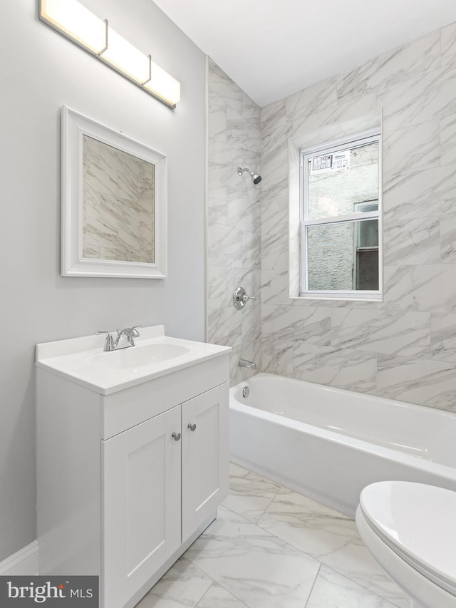 full bathroom featuring tiled shower / bath, vanity, and toilet