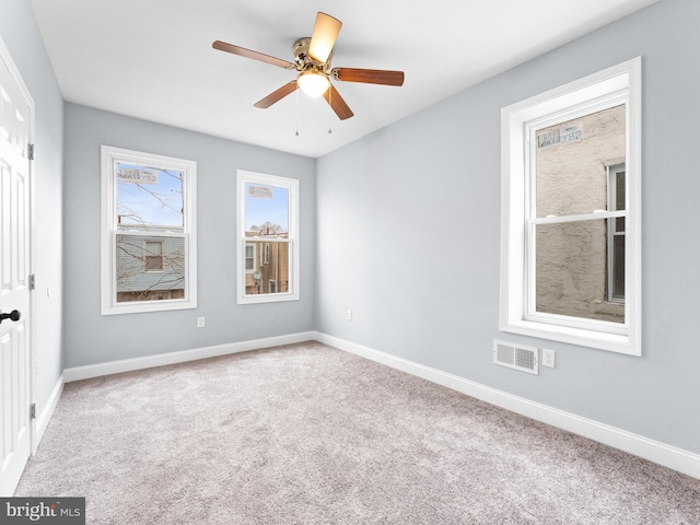 carpeted spare room with ceiling fan