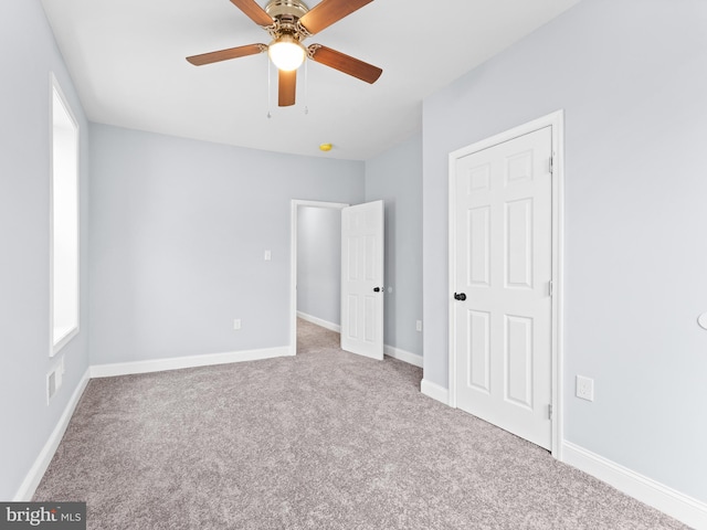 carpeted spare room featuring ceiling fan