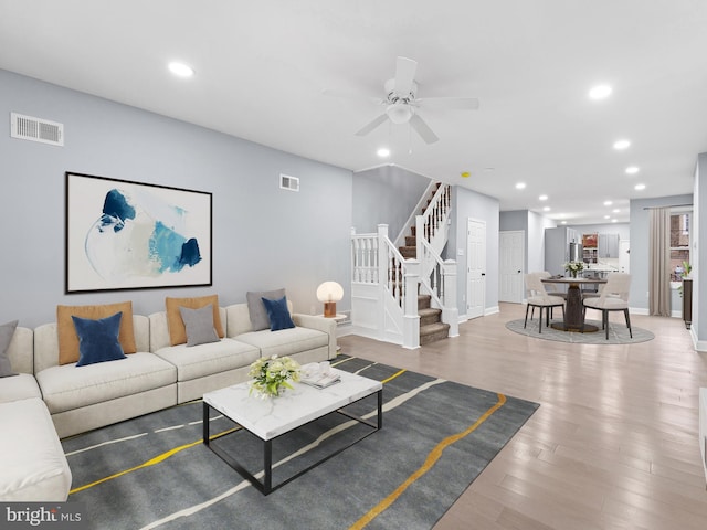 living room featuring hardwood / wood-style floors and ceiling fan