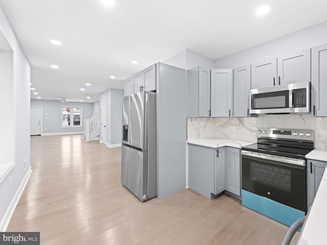 kitchen featuring tasteful backsplash, gray cabinets, and stainless steel appliances