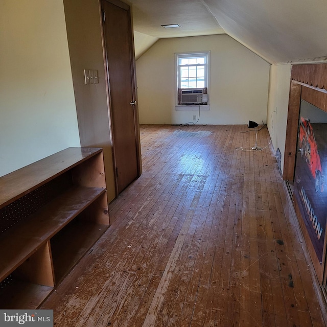 additional living space featuring lofted ceiling, cooling unit, and hardwood / wood-style floors