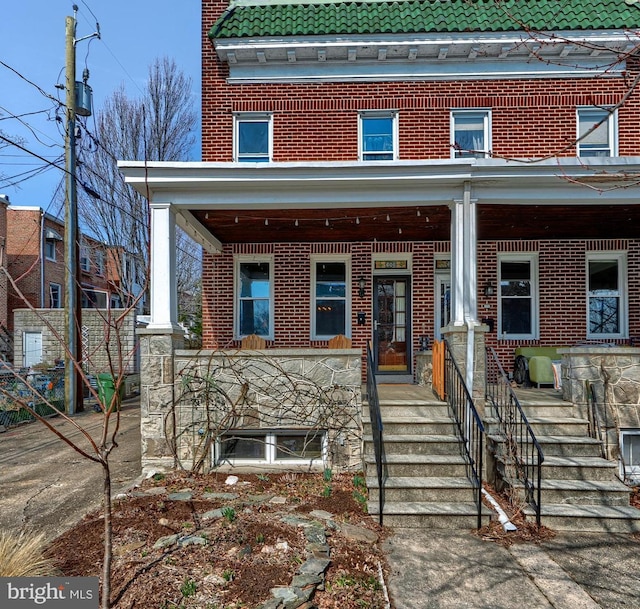 view of front facade with brick siding and a porch