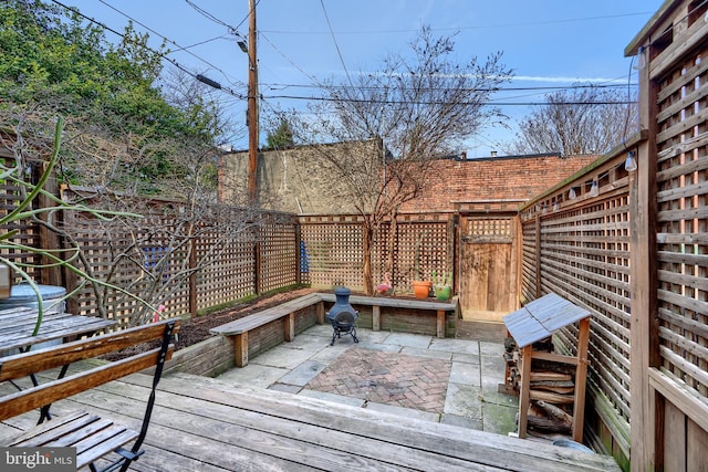 wooden terrace with a patio and a fenced backyard