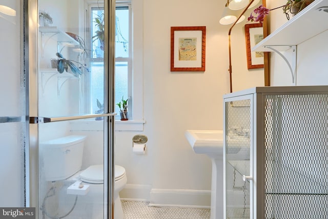 bathroom featuring tile patterned floors, toilet, and baseboards