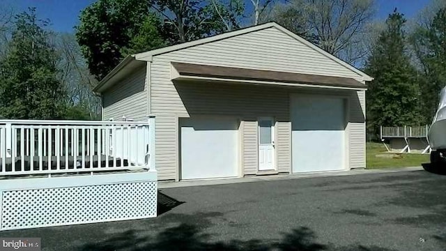 exterior space featuring a deck, an outdoor structure, and a garage