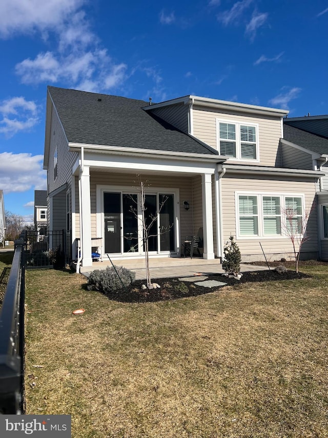 back of house featuring a patio area and a lawn